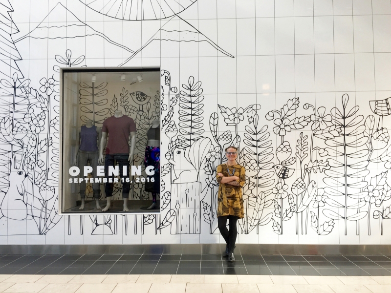 Lisa standing in front of store design she did for the Lululemon shop at Washington Square Mall. 